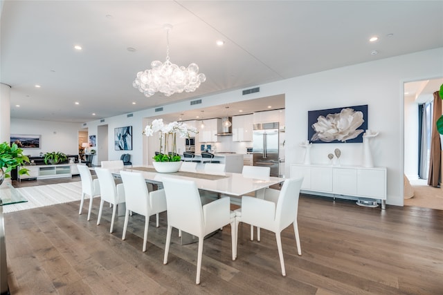 dining space with hardwood / wood-style flooring and an inviting chandelier