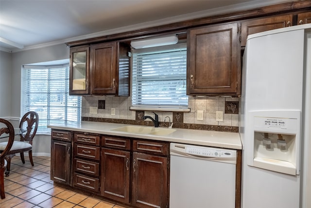 kitchen with crown molding, white appliances, dark brown cabinets, and sink