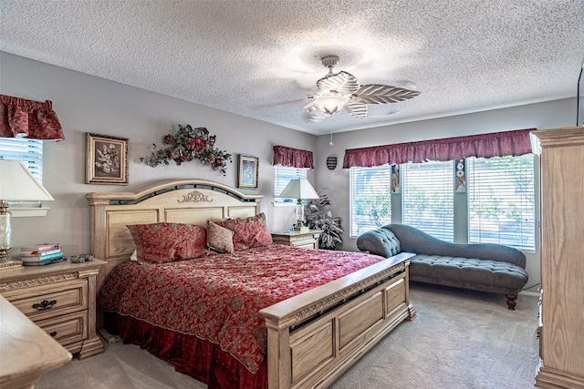 carpeted bedroom with ceiling fan and a textured ceiling