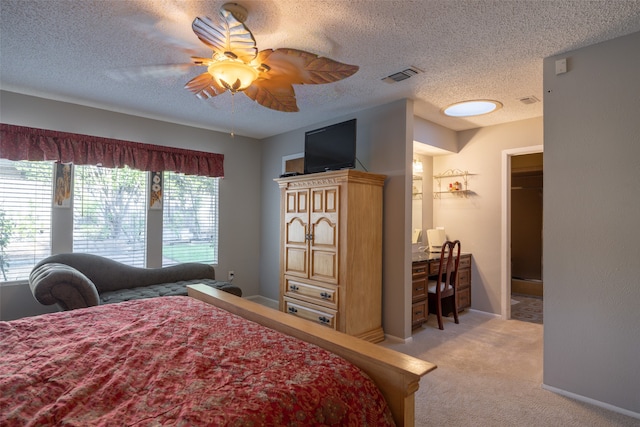 carpeted bedroom featuring a textured ceiling, a walk in closet, ceiling fan, and a closet