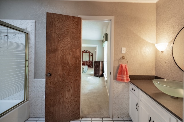 bathroom with shower / bath combination with glass door, vanity, a textured ceiling, and tile patterned floors