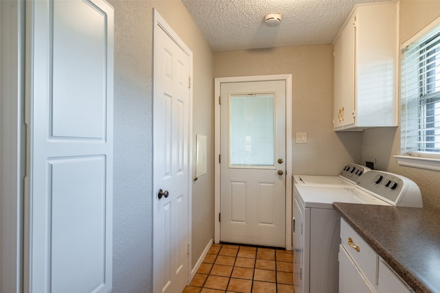 washroom featuring plenty of natural light, cabinets, washer and clothes dryer, and light tile patterned flooring