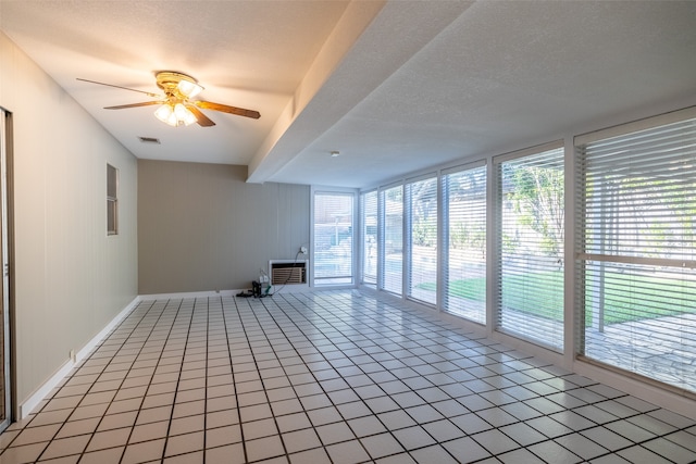 tiled empty room featuring a textured ceiling and ceiling fan