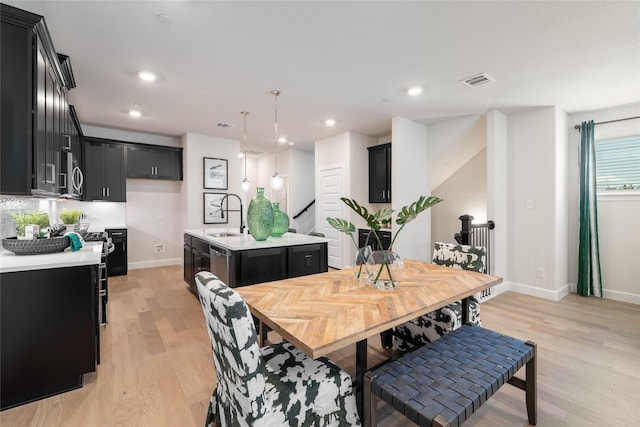 dining space with sink and light hardwood / wood-style floors