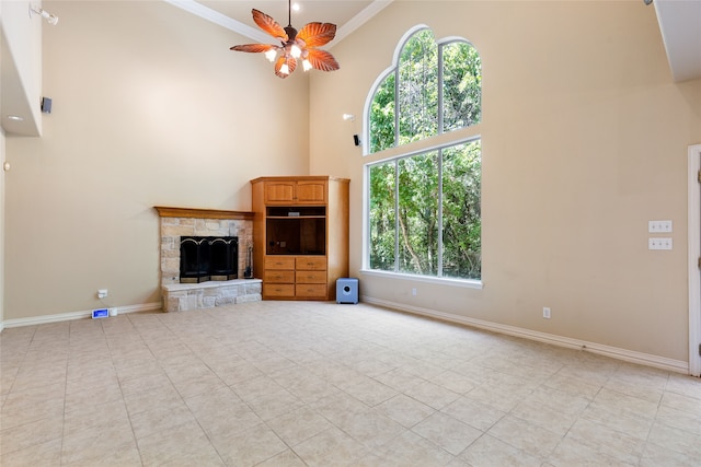 unfurnished living room with ceiling fan, plenty of natural light, a high ceiling, and crown molding