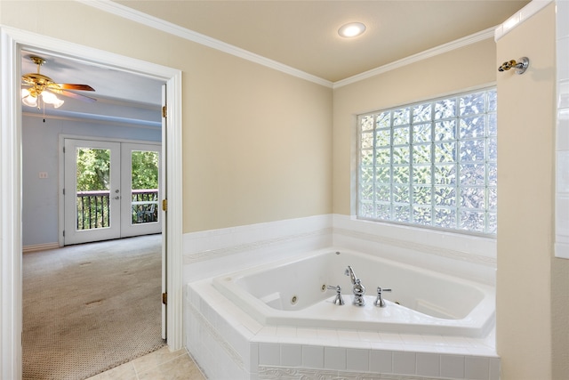 bathroom with crown molding, plenty of natural light, and tiled tub