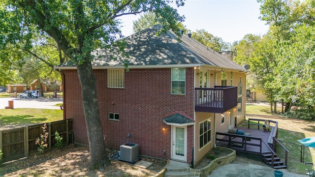 rear view of house with cooling unit and a balcony