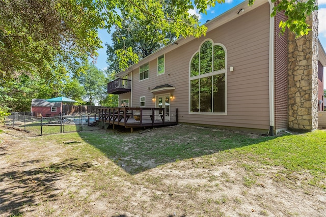 rear view of house with a yard and a wooden deck