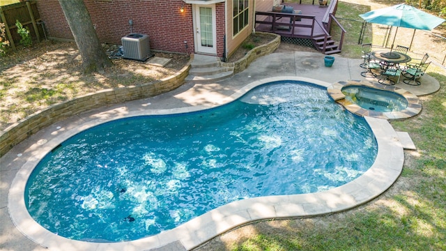 view of swimming pool with cooling unit, a patio, and an in ground hot tub