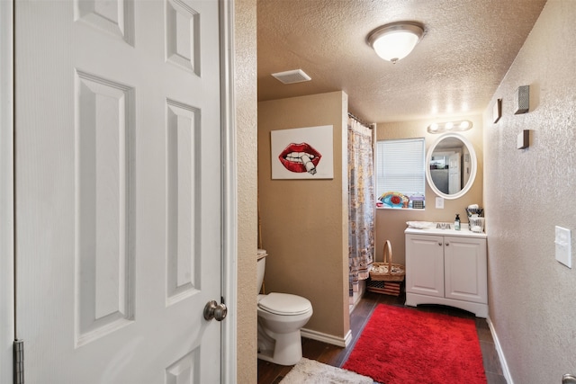 bathroom featuring hardwood / wood-style floors, toilet, a textured ceiling, and vanity