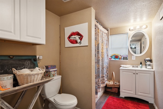 bathroom with toilet, hardwood / wood-style floors, vanity, a textured ceiling, and a shower with curtain