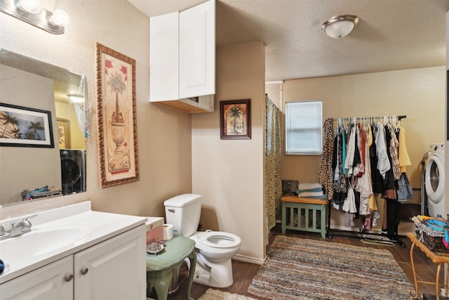 bathroom with hardwood / wood-style flooring, toilet, vanity, washer / clothes dryer, and a textured ceiling