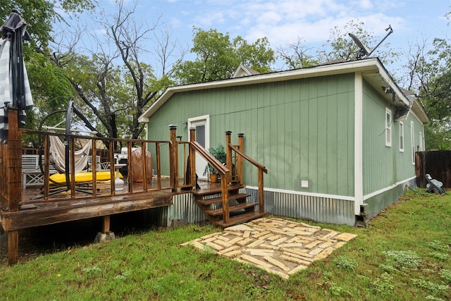 rear view of house featuring a yard and a deck