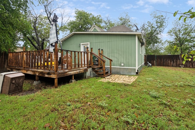 back of property with a lawn and a wooden deck