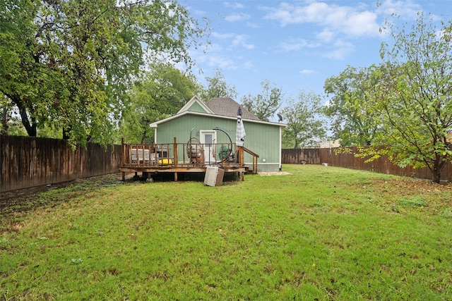 rear view of property featuring a lawn and a wooden deck