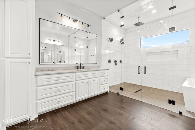 bathroom with hardwood / wood-style floors, vanity, and a shower with door