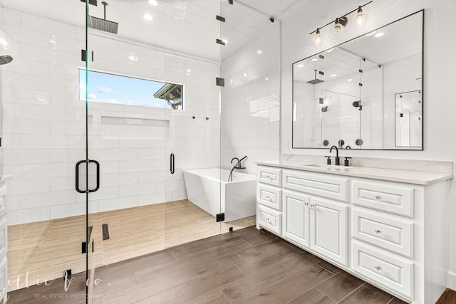 bathroom with vanity, separate shower and tub, and tile walls