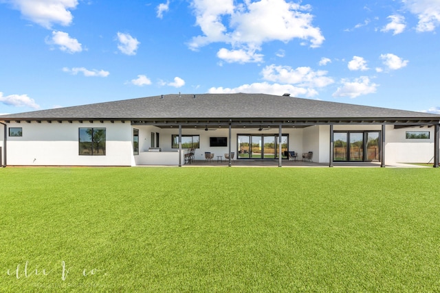 rear view of house with ceiling fan, a yard, and a patio