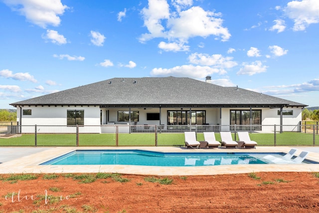 back of property with a fenced in pool, a patio area, and a yard