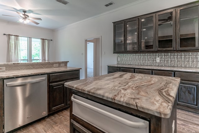 kitchen featuring dishwasher, crown molding, hardwood / wood-style floors, decorative backsplash, and a kitchen island