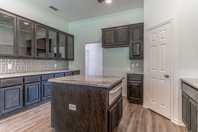 kitchen with decorative backsplash, a center island, dark hardwood / wood-style floors, and dark brown cabinets