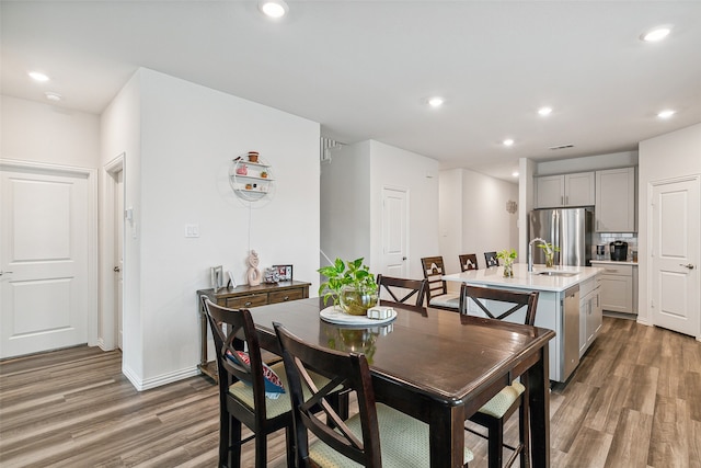 dining space featuring hardwood / wood-style flooring and sink