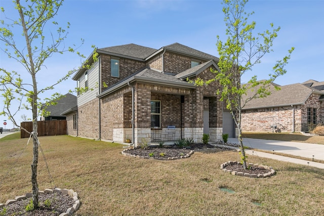 view of front facade with a shingled roof, concrete driveway, fence, a front lawn, and brick siding