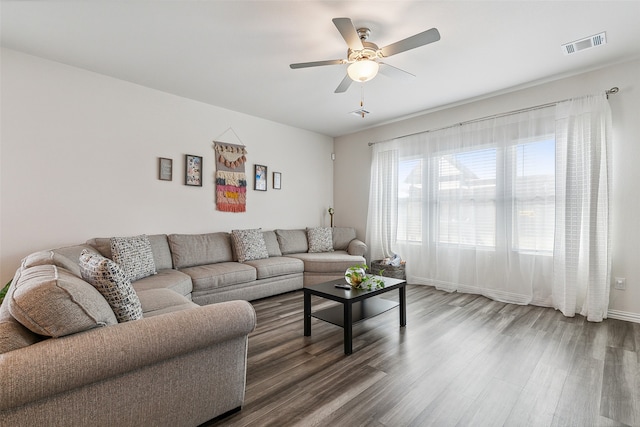 living room featuring ceiling fan and dark hardwood / wood-style floors