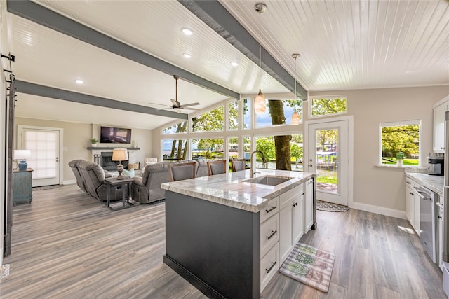 kitchen featuring a center island with sink, pendant lighting, sink, white cabinetry, and ceiling fan