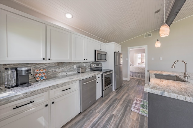 kitchen featuring hardwood / wood-style floors, hanging light fixtures, stainless steel appliances, sink, and white cabinets