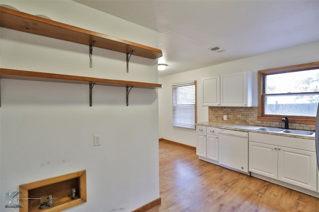 kitchen with white cabinets, white dishwasher, sink, light wood-type flooring, and decorative backsplash