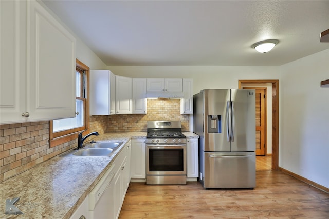 kitchen featuring stainless steel appliances, white cabinetry, light wood-type flooring, and sink