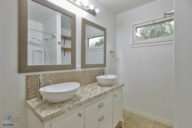 bathroom with backsplash, a shower, vanity, and tile patterned floors