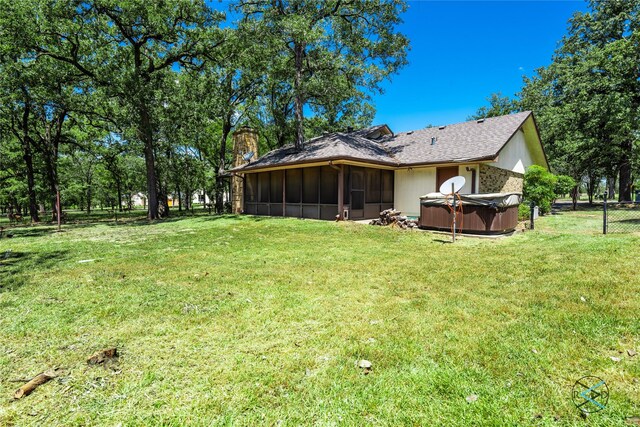 172 Colonial Dr, Mabank, TX 75156 - rear view of house with a chimney, a sunroom, a hot tub, fence, and a lawn