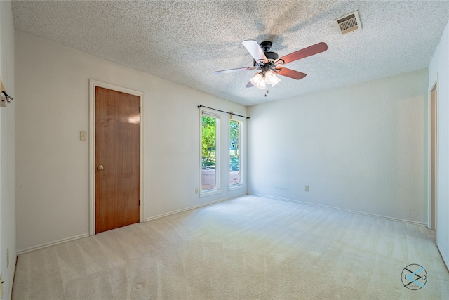 carpeted spare room featuring a textured ceiling and ceiling fan