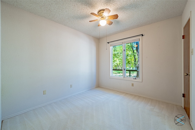 carpeted spare room featuring a textured ceiling and ceiling fan