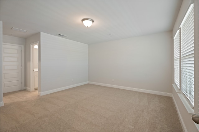 empty room featuring light carpet and a wealth of natural light