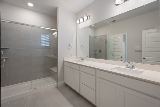 bathroom featuring tile patterned flooring, a shower with door, and vanity