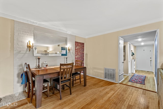 dining area with crown molding and light hardwood / wood-style floors