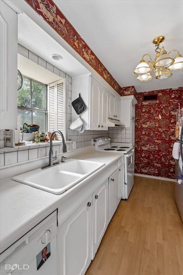 kitchen with white appliances, light hardwood / wood-style flooring, an inviting chandelier, sink, and white cabinets