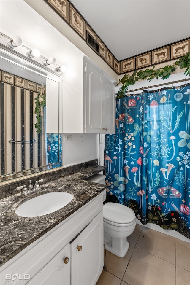 bathroom featuring tile patterned flooring, vanity, and toilet