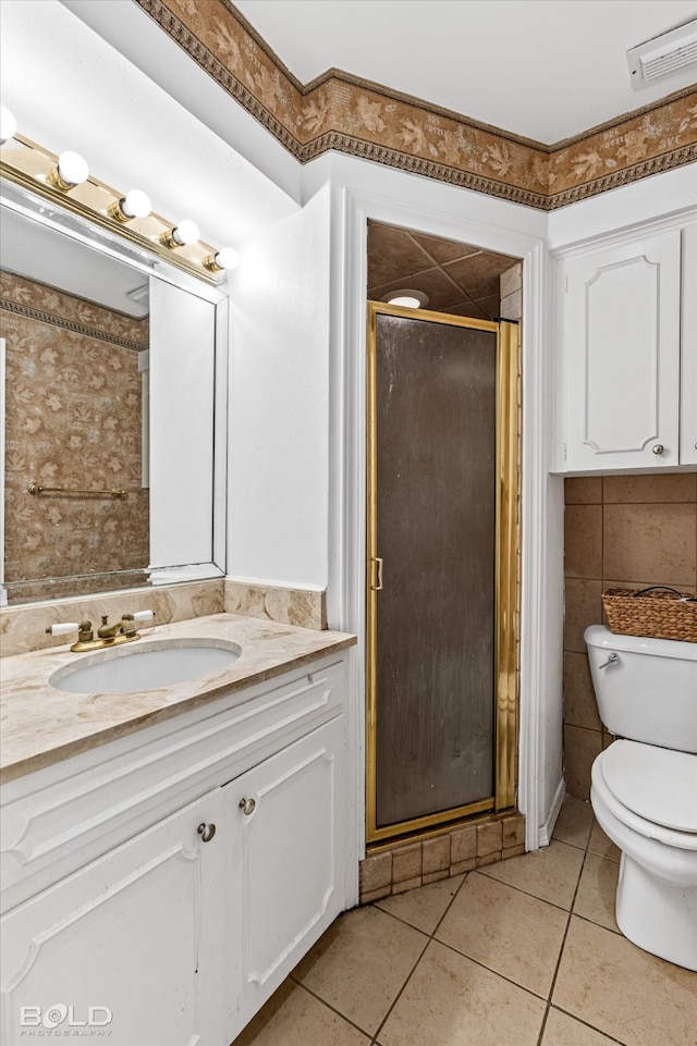 bathroom with vanity, walk in shower, tile patterned flooring, tile walls, and toilet