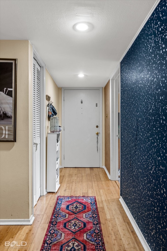 hallway with hardwood / wood-style flooring and a textured ceiling