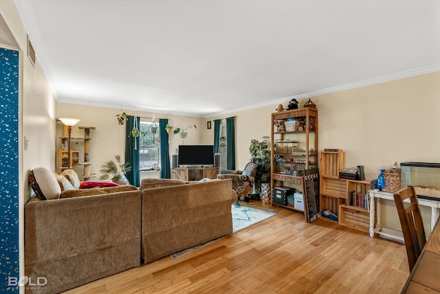 living room with light hardwood / wood-style floors and crown molding