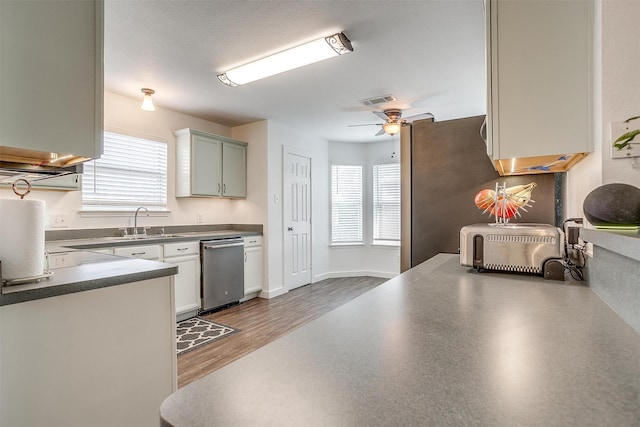 kitchen featuring hardwood / wood-style floors, a textured ceiling, dishwasher, sink, and ceiling fan