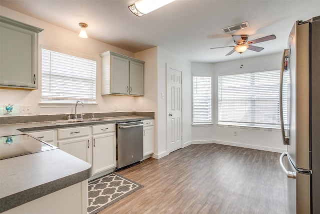 kitchen featuring stainless steel appliances, sink, light wood-type flooring, and ceiling fan