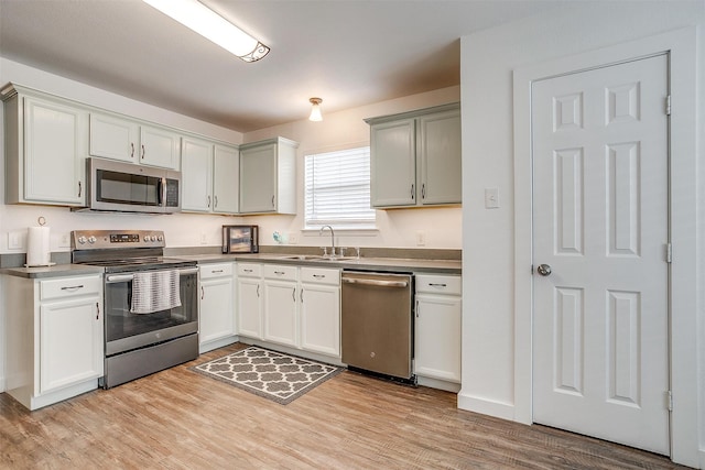 kitchen with light hardwood / wood-style flooring, stainless steel appliances, and sink