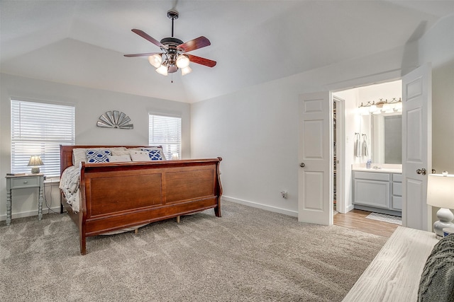 carpeted bedroom featuring lofted ceiling, ensuite bathroom, and ceiling fan