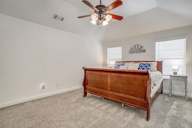 carpeted bedroom featuring lofted ceiling, multiple windows, and ceiling fan