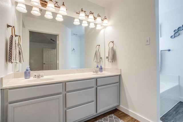 bathroom featuring a tub to relax in, hardwood / wood-style flooring, and vanity